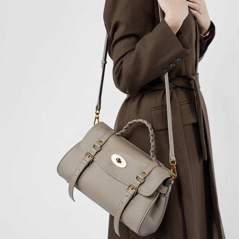 Woman wearing brown trench coat with taupe leather satchel crossbody bag