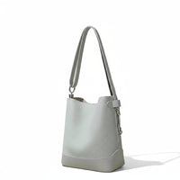 Light gray leather bucket bag with shoulder strap on a neutral background