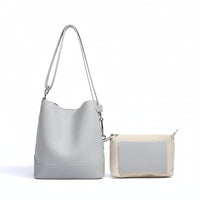 Light grey leather bucket bag with matching beige and grey pouch on white background