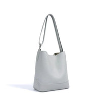 Light gray leather bucket bag with shoulder strap on white background
