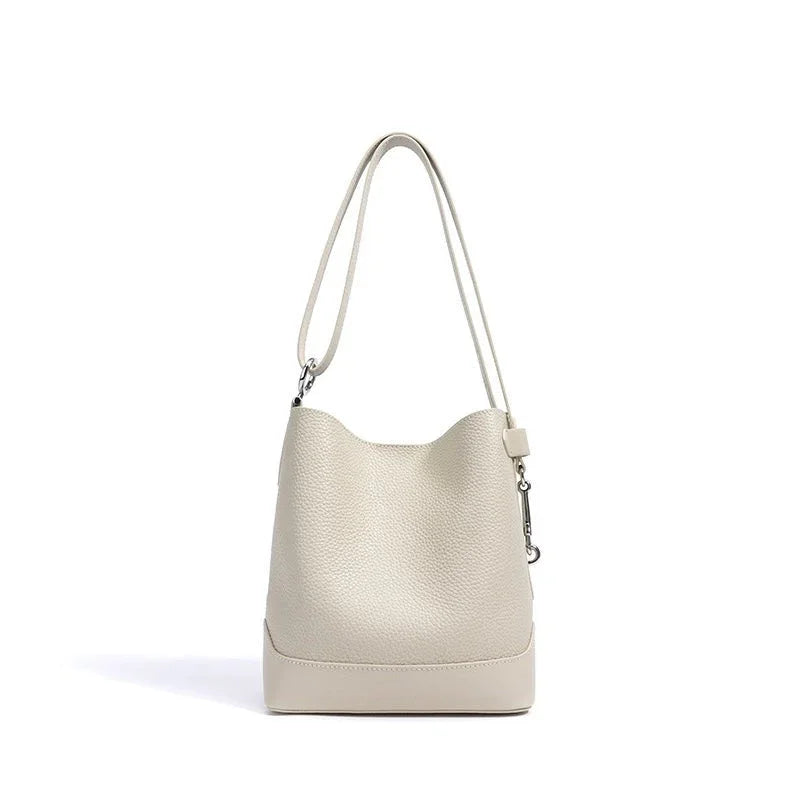 Ivory leather bucket bag with shoulder strap on white background