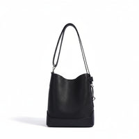 Black leather bucket bag with shoulder strap on white background