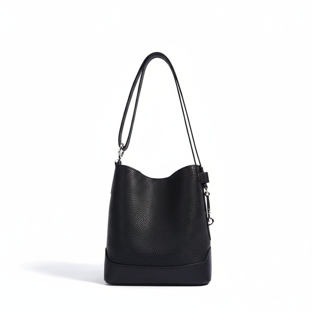 Black leather bucket bag with shoulder strap on white background