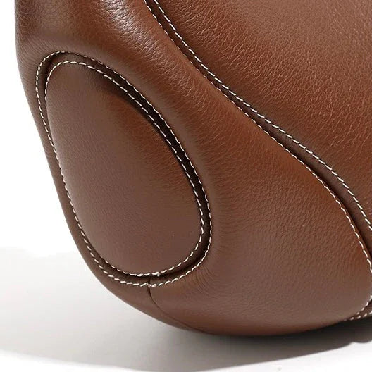Close-up of brown leather car neck pillow with white stitching