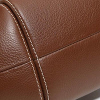 Close-up of brown leather upholstery with visible stitching detail