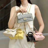 Woman holding quilted leather handbags in gray, cream, yellow, black, and pink with chain straps