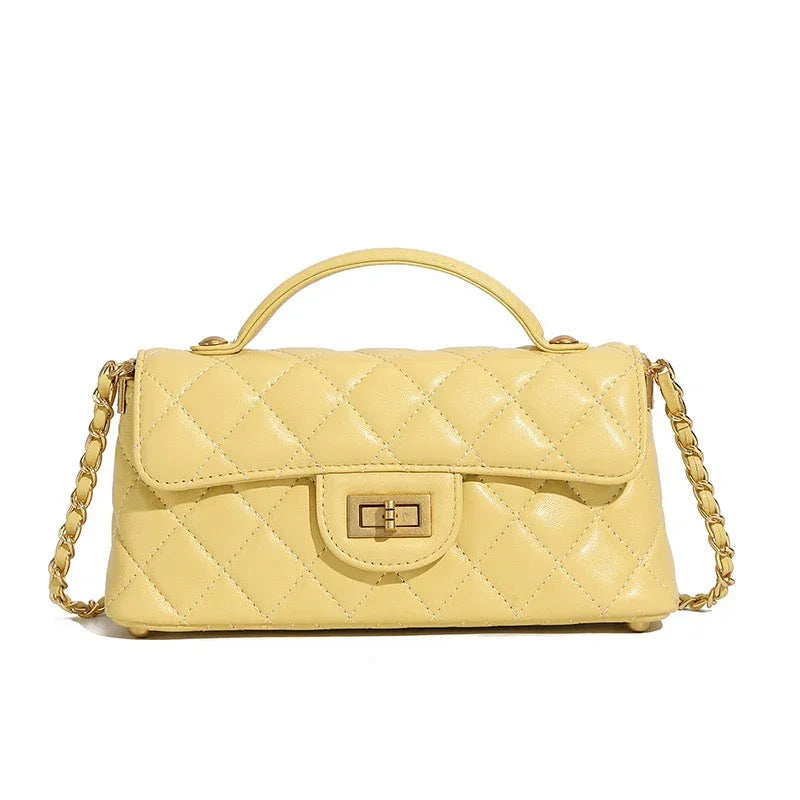 Yellow quilted leather handbag with top handle, chain strap, and gold turn-lock closure