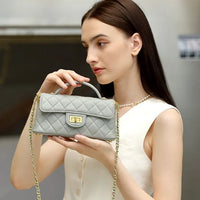 Woman holding quilted gray leather handbag with gold chain strap
