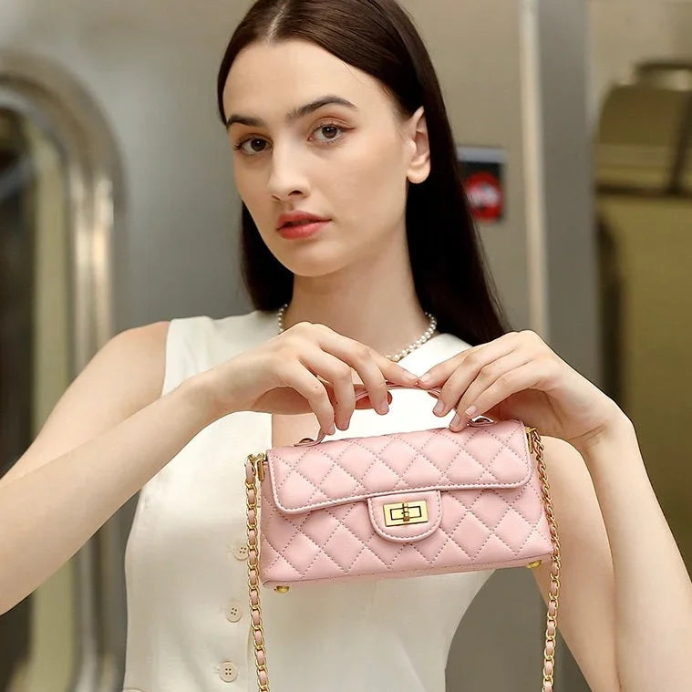 Woman in a white dress holding a quilted pink shoulder bag with gold chain strap