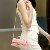 Woman in white outfit carrying pink quilted crossbody purse with gold chain strap