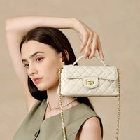 Woman modeling a quilted cream leather handbag with gold chain strap