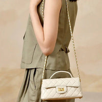 Woman in khaki outfit with quilted white leather handbag and gold chain strap