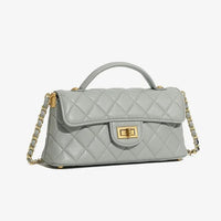 Quilted light gray leather handbag with gold chain strap and turn-lock clasp on white background