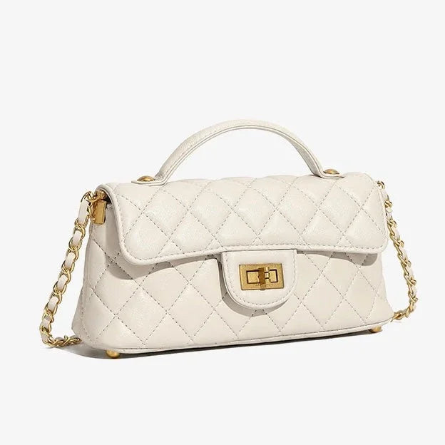 White quilted leather handbag with gold chain strap and top handle on white background