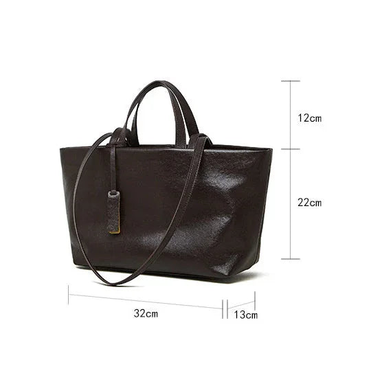Black leather tote handbag with long strap and size dimensions 32x13x22 cm