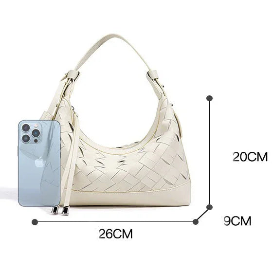 Cream woven leather shoulder bag with handle, next to smartphone, size 26x20x9 cm