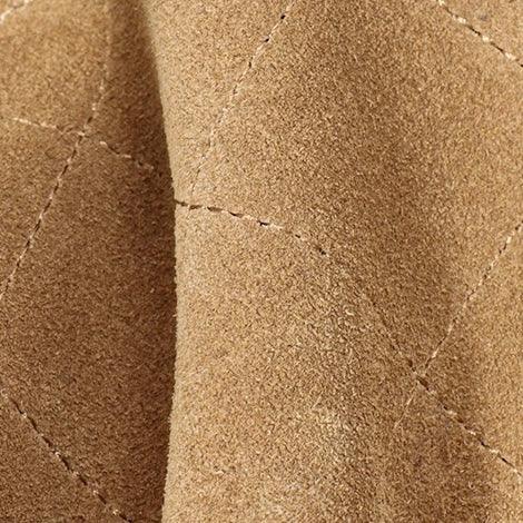 Close-up of tan suede quilted fabric with visible stitching detail