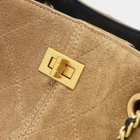 Tan suede handbag with gold turn lock clasp and quilted stitching detail