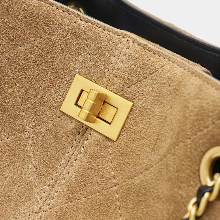 Tan suede handbag with gold turn lock clasp and quilted stitching detail