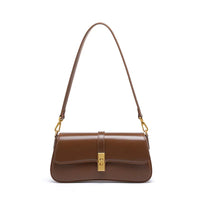 Brown leather shoulder bag with gold buckle and detachable strap on white background