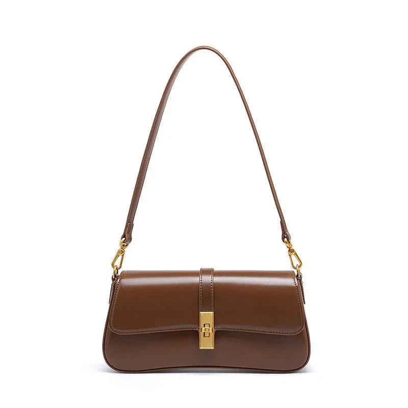 Brown leather shoulder bag with gold buckle and detachable strap on white background