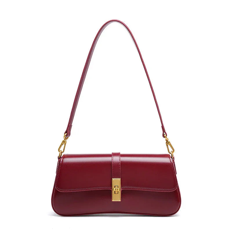 Burgundy leather shoulder bag with gold clasp and strap hardware on white background