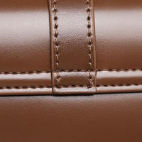 Close-up of brown leather bag with detailed stitching and smooth finish