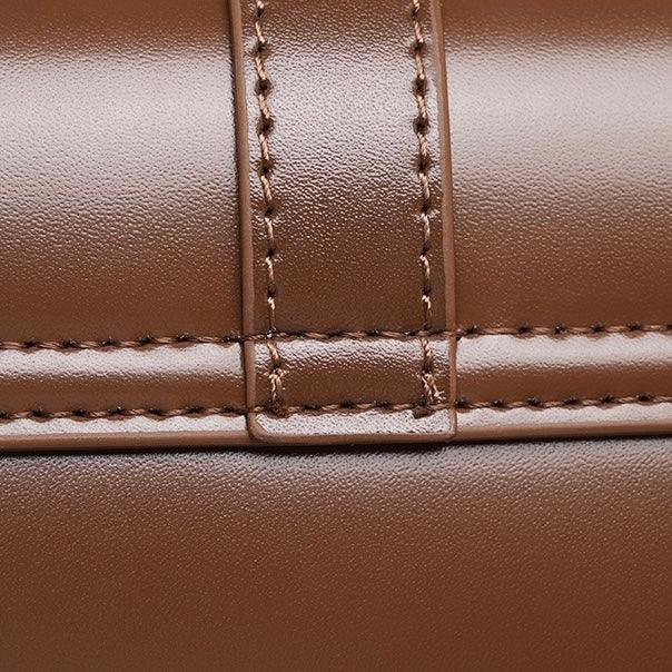 Close-up of brown leather bag with detailed stitching and smooth finish
