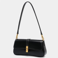 Black leather shoulder bag with gold hardware on a white background