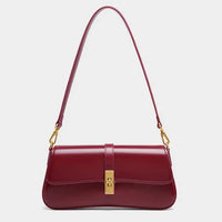 Sleek burgundy leather shoulder bag with gold clasp and hardware on a plain background