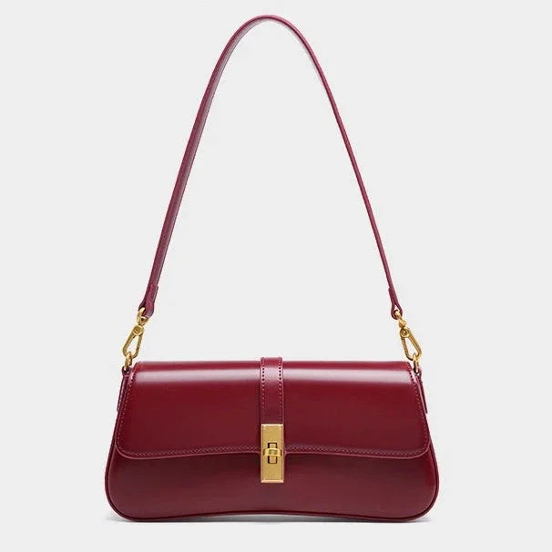 Sleek burgundy leather shoulder bag with gold clasp and hardware on a plain background