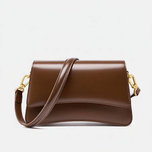 Brown leather crossbody bag with gold hardware on a white background