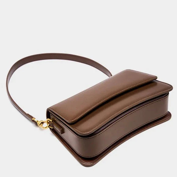Brown leather shoulder bag with gold clasp on a white background
