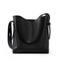 Black leather bucket bag with adjustable strap on white background