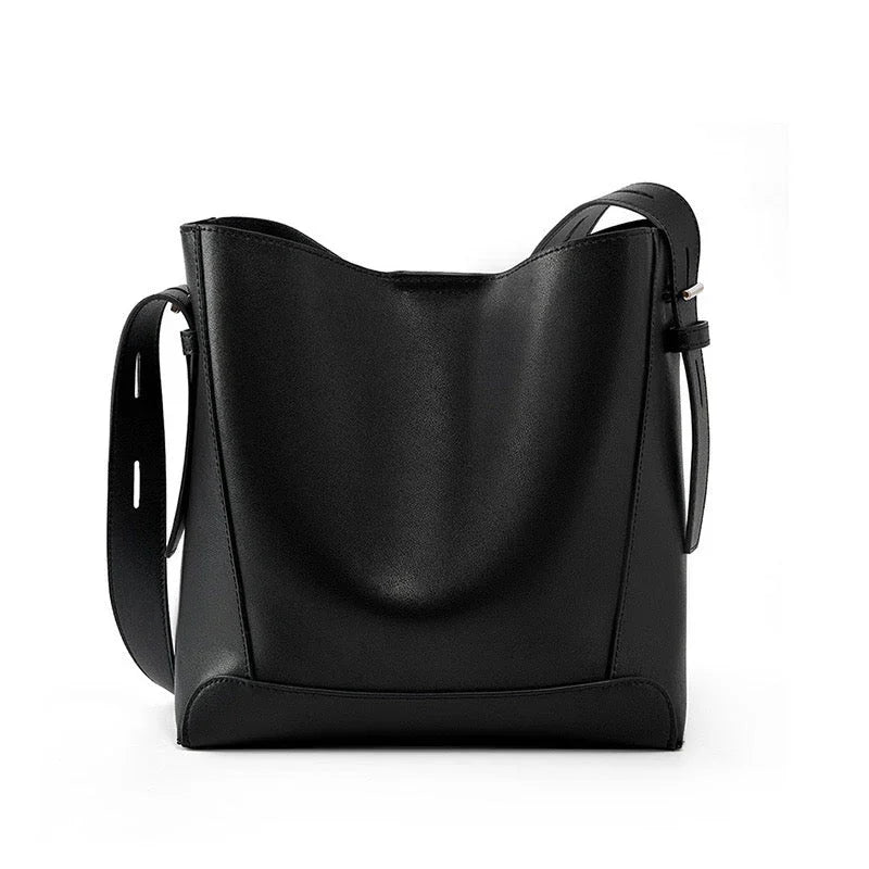 Black leather bucket bag with adjustable strap on white background