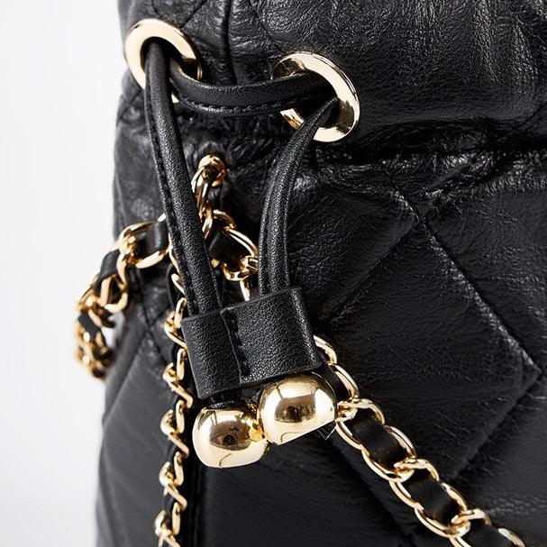 Quilted black leather bag with gold chain strap and drawstring closure detail