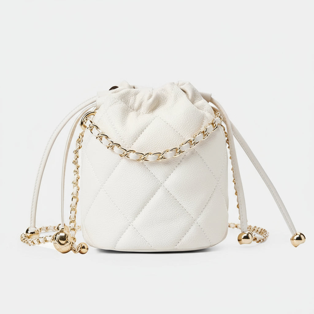 White quilted leather bucket bag with gold chain strap on white background