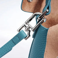 Close-up of blue leather handbag strap with silver metal clasp
