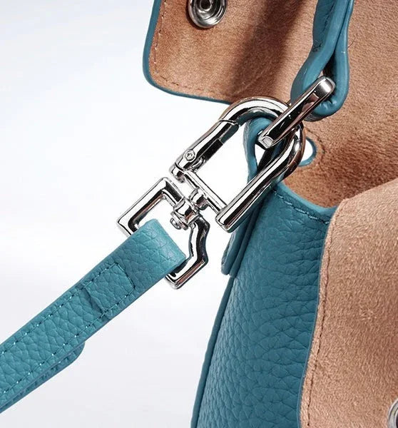 Close-up of blue leather handbag strap with silver metal clasp