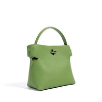 Green leather handbag with top handle and silver clasp on white background