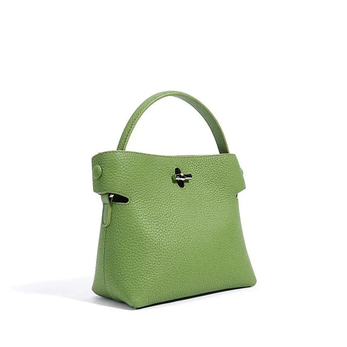 Green leather handbag with top handle and silver clasp on white background