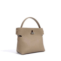 Beige pebbled leather handbag with top handle and silver clasp on white background