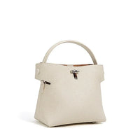 Cream leather handbag with top handle, minimalist style, silver clasp, on white background