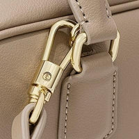Beige leather handbag with gold hardware clasp and detailed stitching