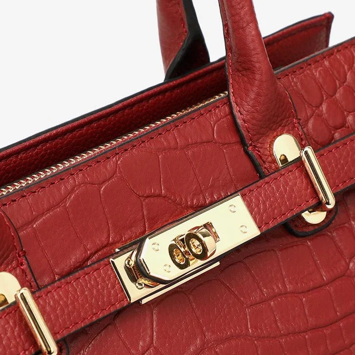 Red crocodile-embossed leather handbag with gold hardware and secure lock detail