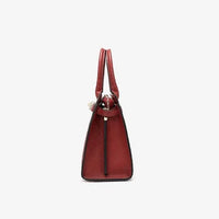 Side view of textured red leather handbag with dual handles on white background