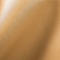 Closeup of tan faux leather texture with subtle grain and soft creases