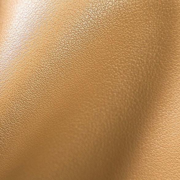 Closeup of tan faux leather texture with subtle grain and soft creases