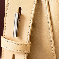 Close-up of beige leather bag strap with silver buckle and fine stitching detail