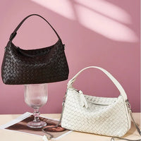 Black and white woven handbags displayed on a pink background with soft lighting